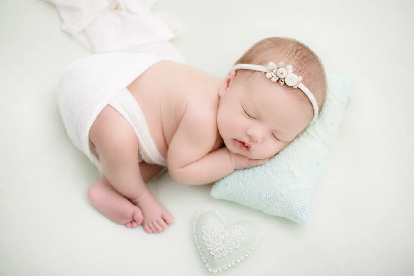 Newborn baby in a simple light studio pose used for comparing photography package value