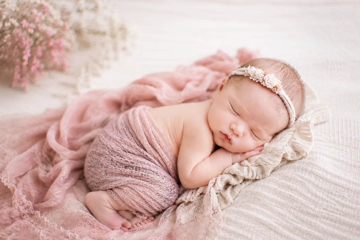 Newborn baby in a soft pink wrap for clothing and clothing co-ordination planning