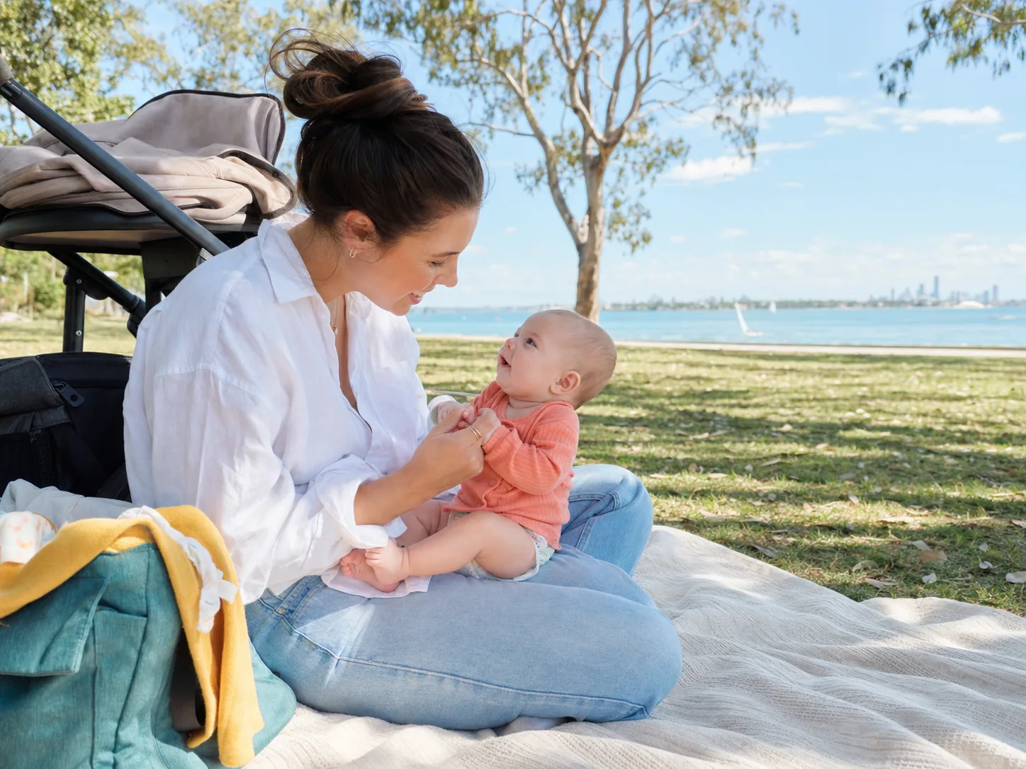 Brisbane mum sharing a playful moment with her young baby beside the bay